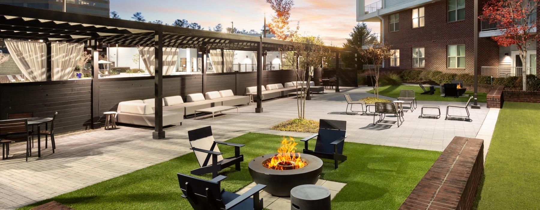  an outdoor lounge space near a fire pit